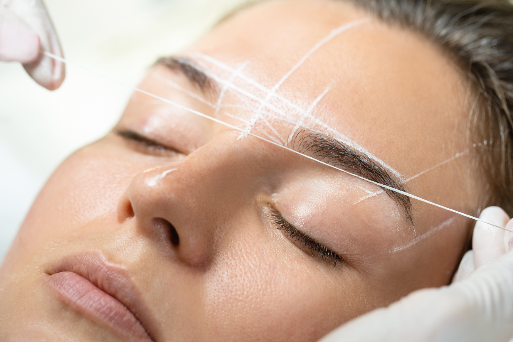 Woman during Professional Eyebrow Mapping Procedure